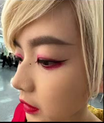 Close-up creative makeup with sculpted brows, pink eye colour and red lips